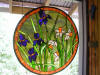 Stained glass window hanging with irises and daffodils